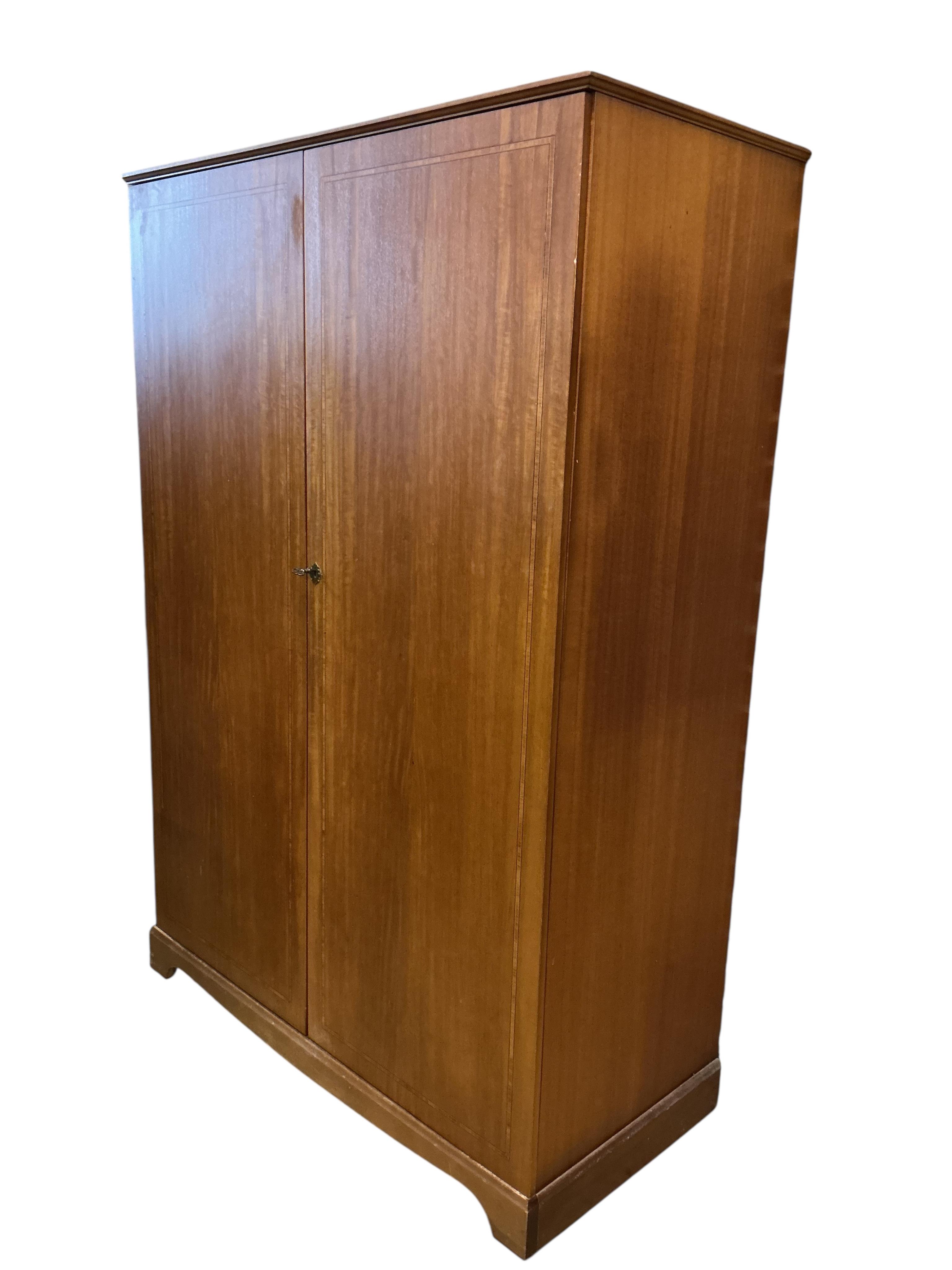 A mid century teak Beithcraft furniture bedroom suite, comprising a two door wardrobe, a kneehole dressing table with stool, headboard and a five drawer chest